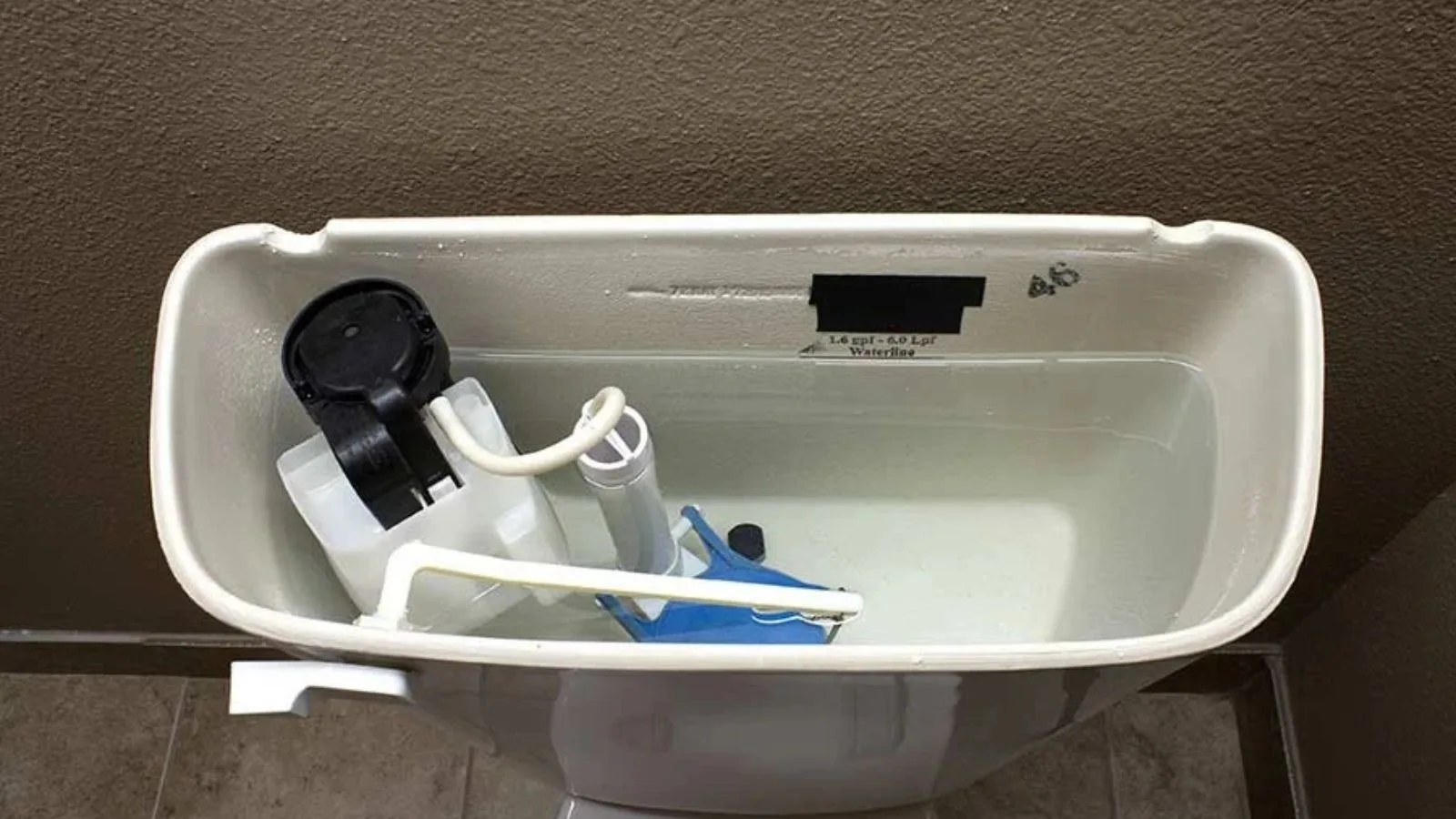 Toilet tank with the lid off showing the fill valve and flapper